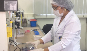 Perita criminal analisa amostra de DNA em laboratório