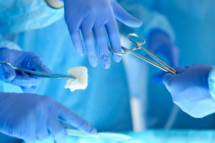 Surgeons hands holding and passing surgical instrument to other compressa paciente condenação Médico